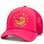 A bright pink trucker hat with a yellow-green embroidered graphic on the front that reads 'RESPECT THE LOCAL' around a wave illustration, shown on a clean white background.